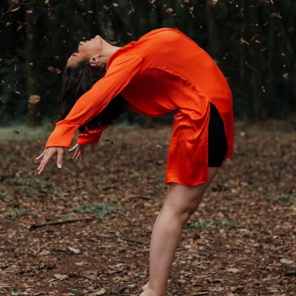 Person stretching calmly by a window, embodying well-being and flexibility.